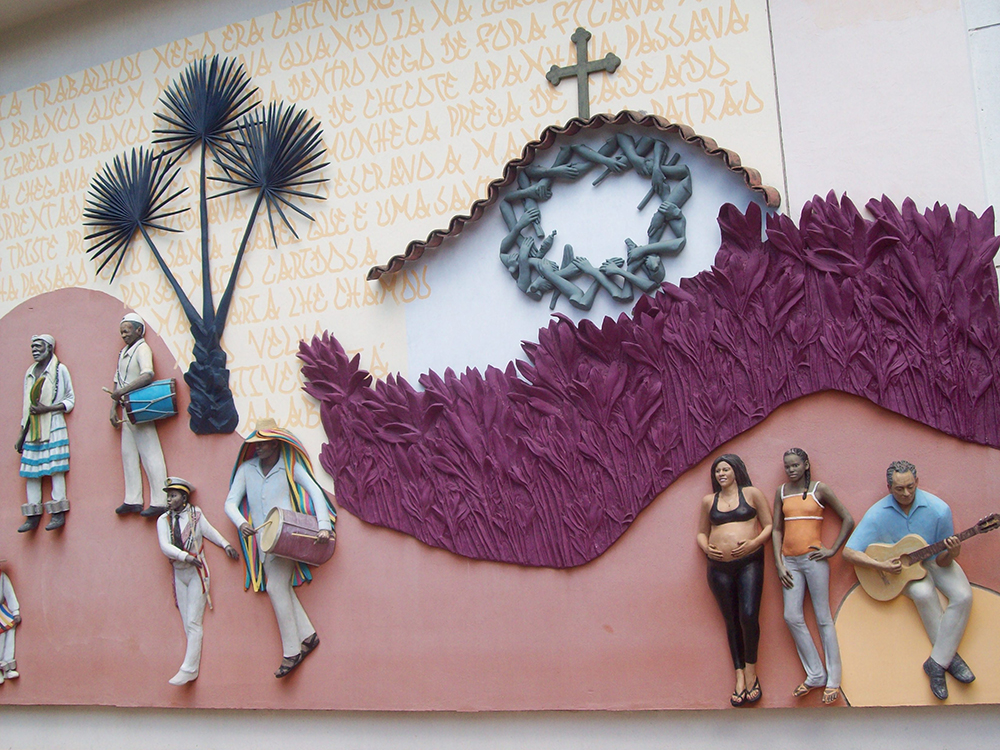 Painel retratando pessoas em uma roda de samba e uma igreja com imagens tridimensionais