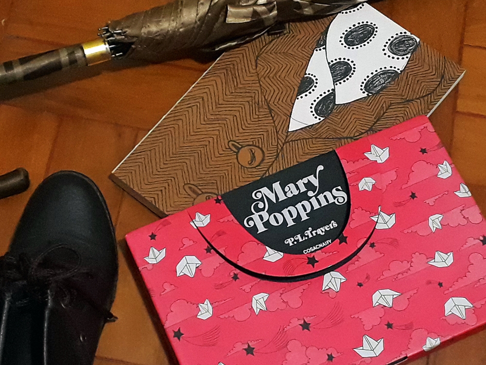 Mary Poppins: Foto do livro Mary Poppins, publicado pela editora Cosac Naify, cuja capa simula a roupa da parte superior do corpo da personagem, ou seja, uma camisa de com estampa de bolinhas com um casaco listrado por cima. O livro está parcialmente inserido dentro de sua luva, que simula a maleta usada pela personagem. Abaixo há um pé de bota de cor escura e acima um guarda chuvas fechado.
