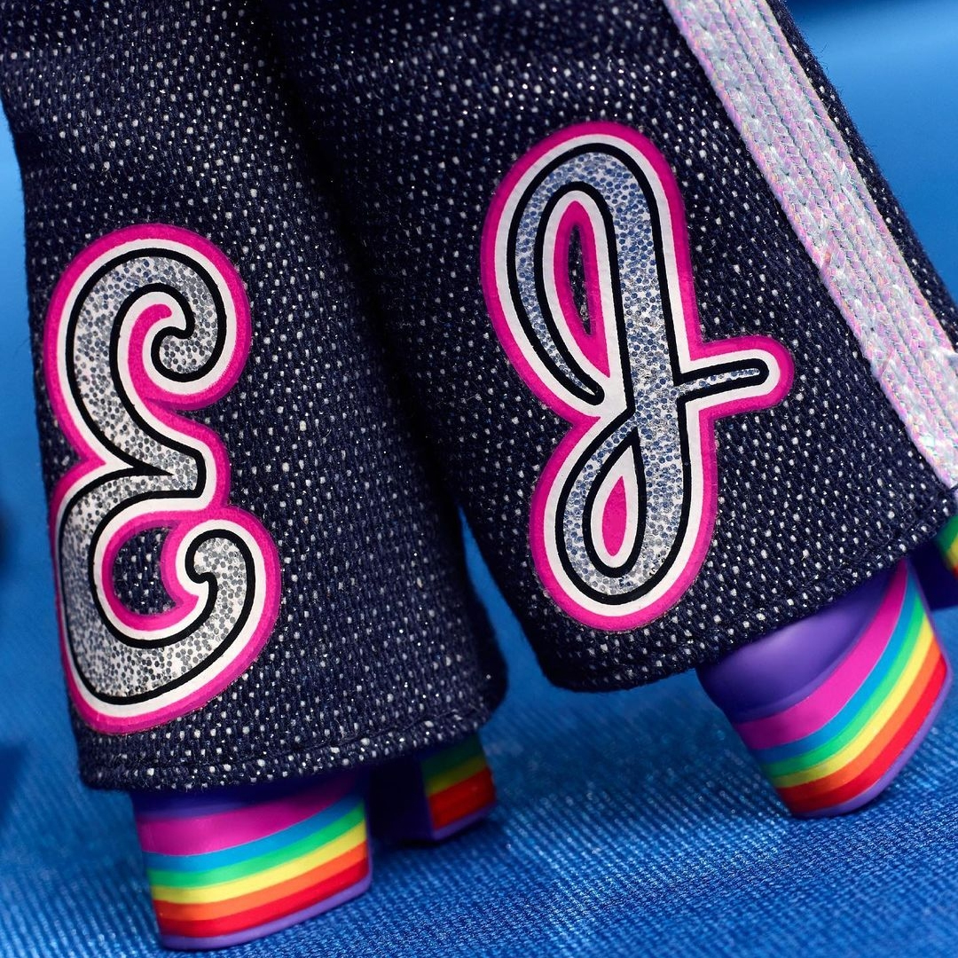 Barbie Elton John: detalhe da calça com bordado das iniciais do artista na barra (E em um perna e J na outra) e das plataformas de arco-íris.