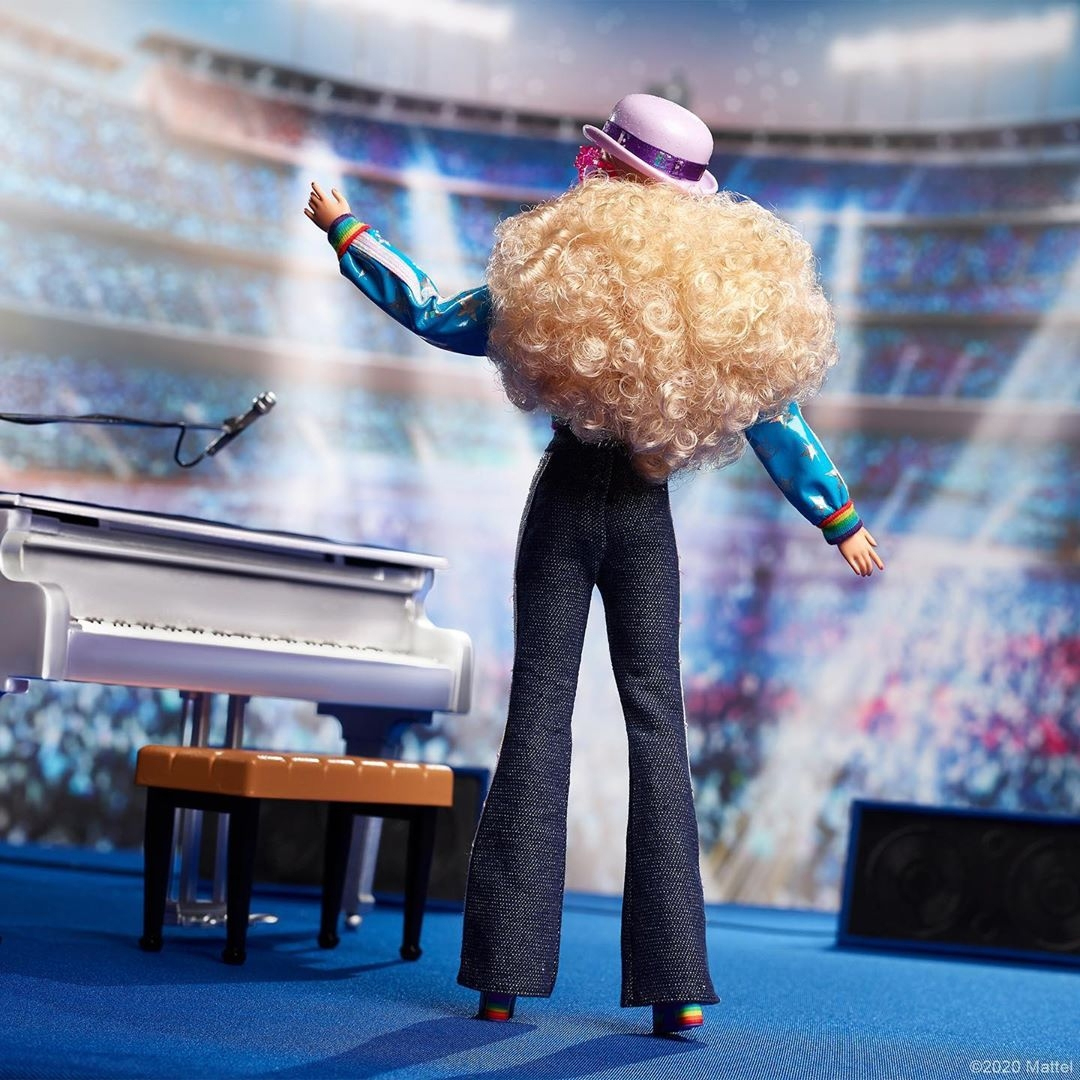 Barbie Elton John: visão da boneca de corpo inteiro, de costas.