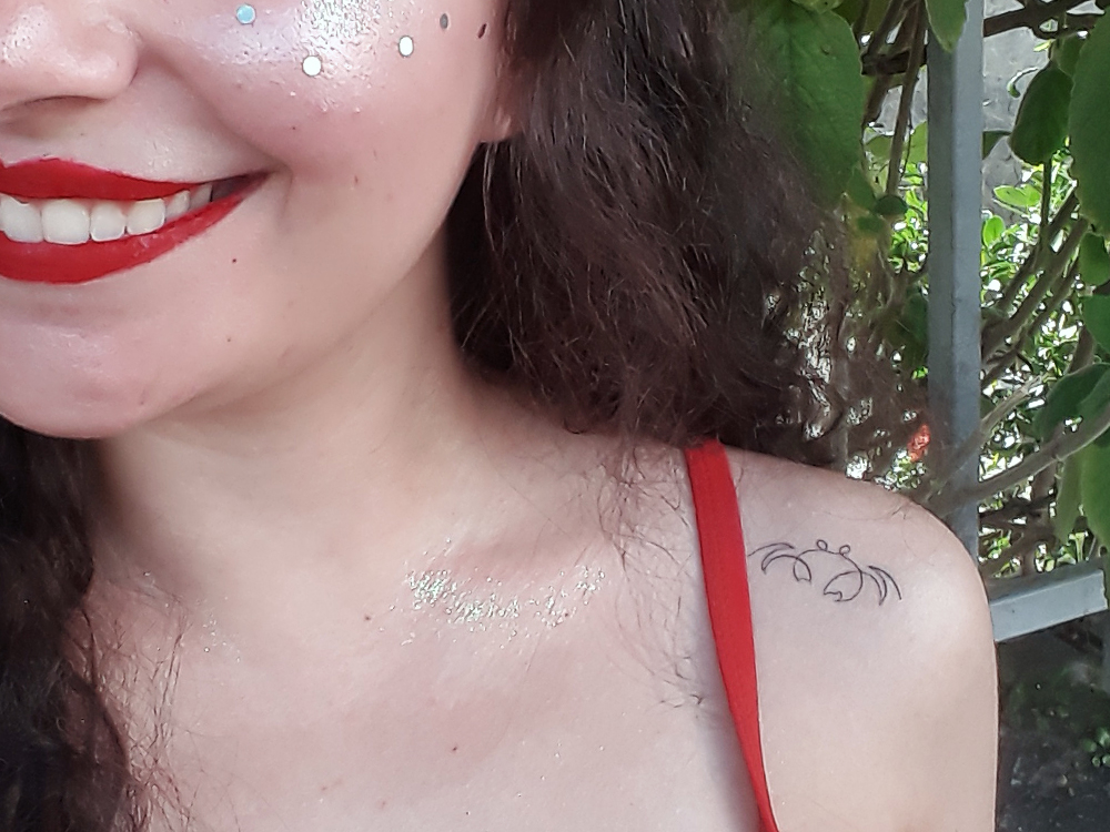 Foto d tatuagem de caranguejo já cicatrizada, com a linha bem fina e preta.