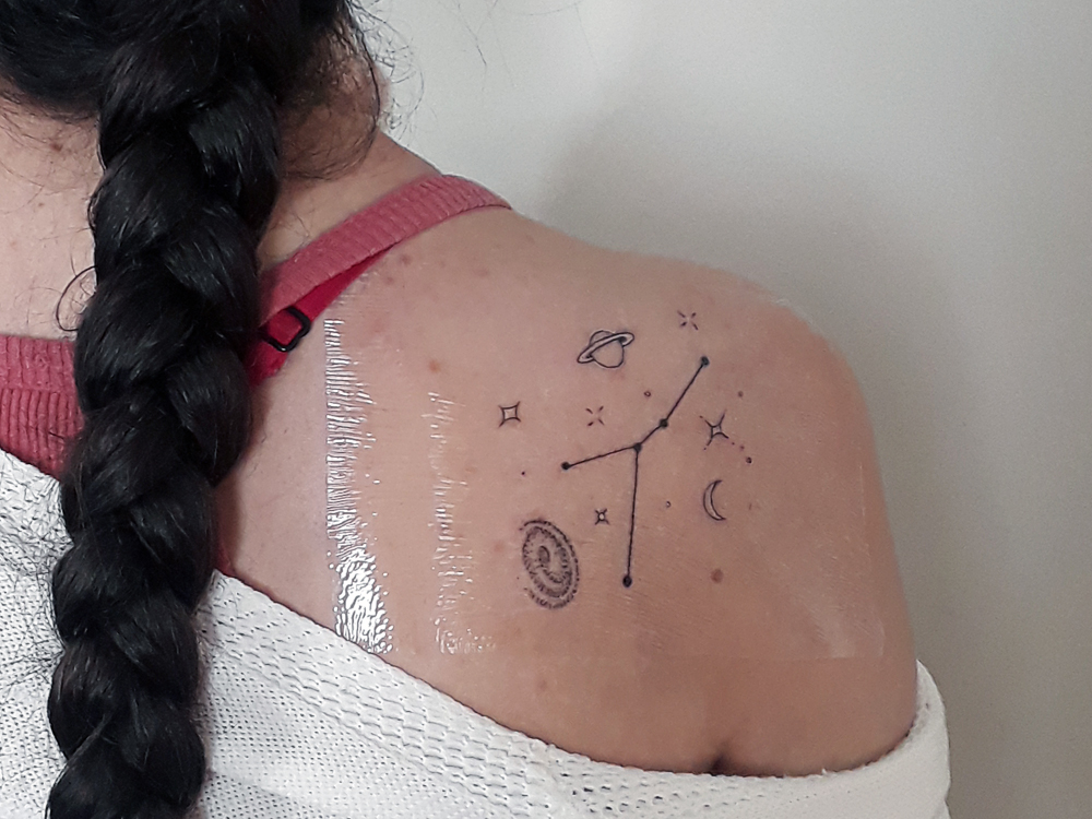 Foto da tatuagem da constelação de Câncer recém feita, ainda com plástico protetor.