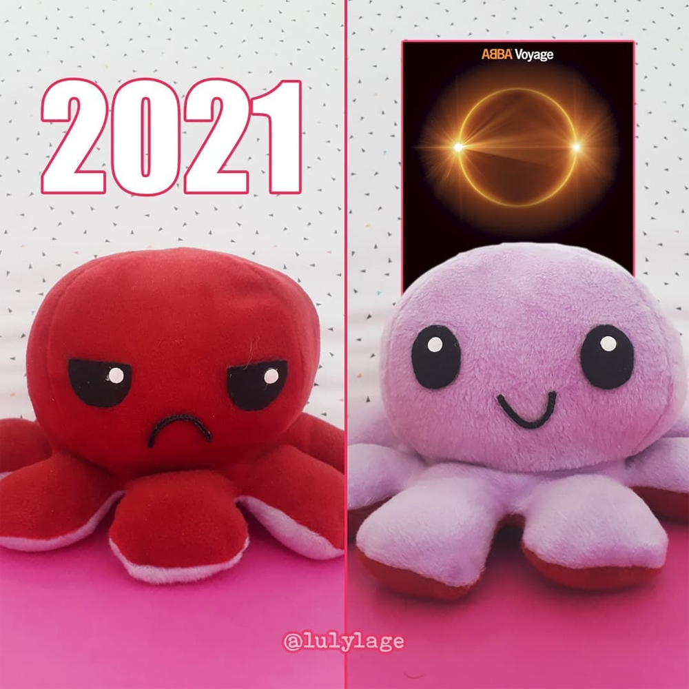 Duas imagens de um mesmo polvinho do humor, que tem um lado bravo e outro feliz, ambas lado a lado. Na primeira, com a expressão brava, tem em cima o número 2021, referente ao ano, e a segunda, da expressão feliz, tem a capa do disco ABBA Voyage. A capa é preta com um eclipse lunar de tom dourado abaixo do nome do mesmo.