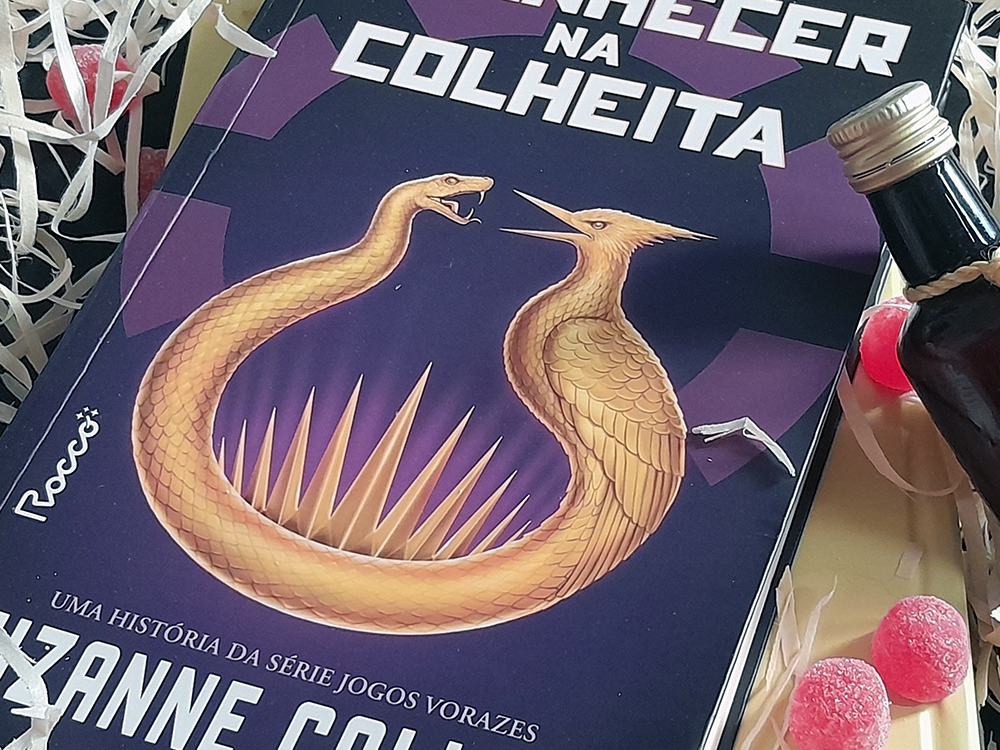 ova foto do livro no mesmo cenário, dessa vez em close na ilustração , sendo possível visualizar apenas a tampa da garrafa, três jujuba e o fundo amarelo do livro que se encontra em baixo além dele.