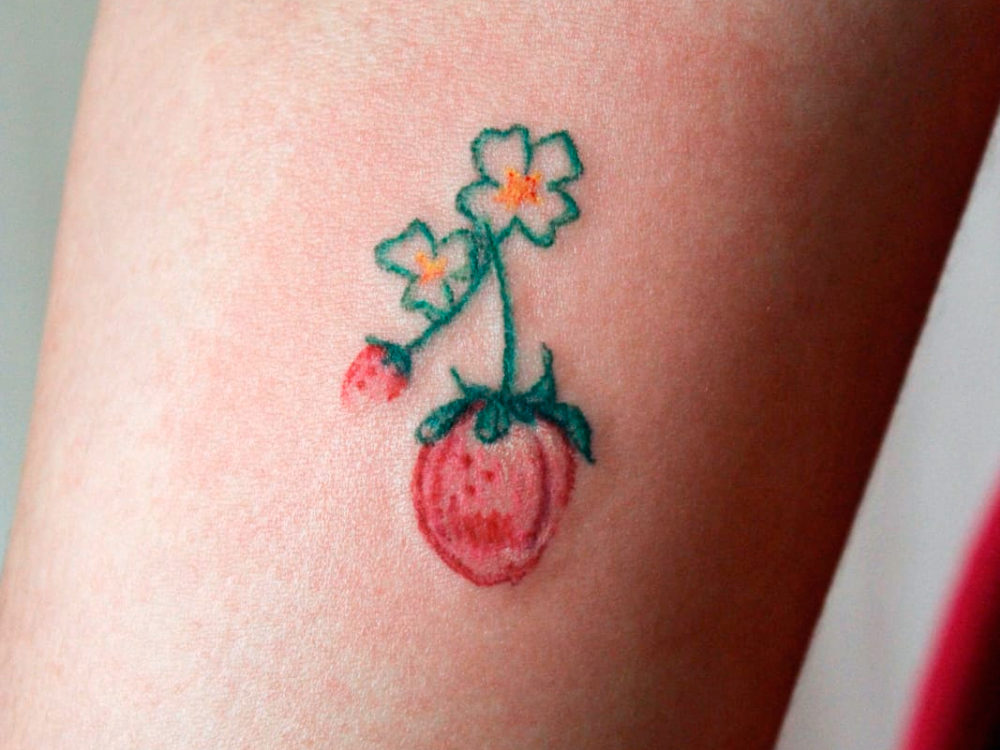 Close da tatuagem de morango, com mais detalhes.