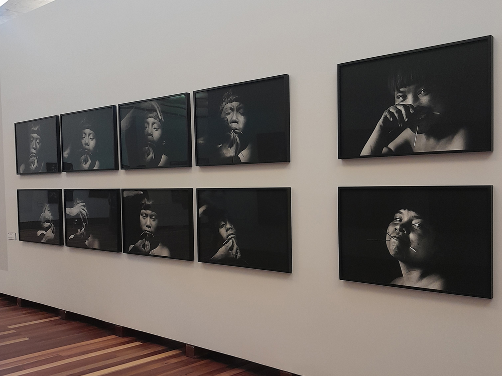 Parede com dez fotos em preto e branco do rosto de pessoas indígenas
