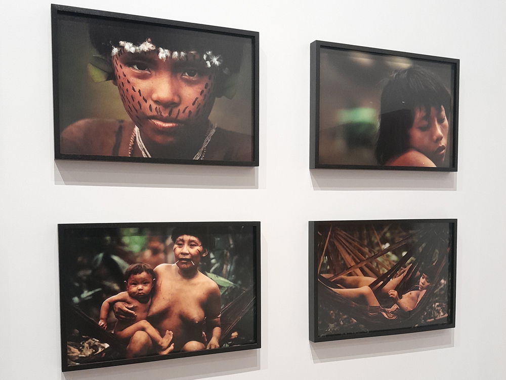 Quatro fotografias de pessoas indígenas, duas em close e duas mostrando parte dos corpos, sendo a primeira delas uma criança e as outras adultos.