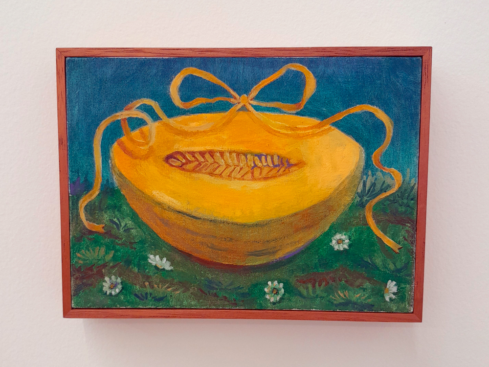 Pintura de meio melão amarelo com uma fita amarrada em laço sobre ele. O melão está sobre a grama, com pequenas flores brancas ao redor, e fundo azul.