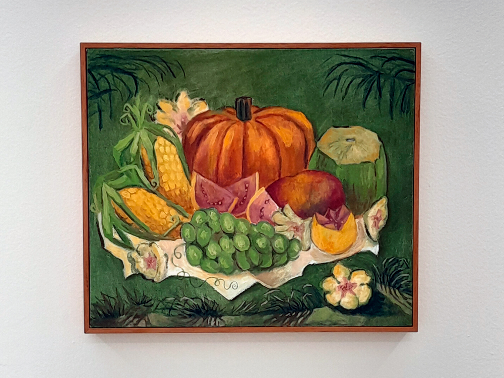 Pintura de uma composição de alimentos sobre um pano claro. Ao centro, uma abóbora grande, cercada por milho verde, coco verde, fatias de melancia, manga, melão, cacho de uvas verdes e flores. O fundo é verde, com folhagens desenhadas.