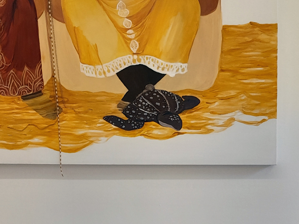 Detalhe da tartaruga aos pés da idosa na pintura.