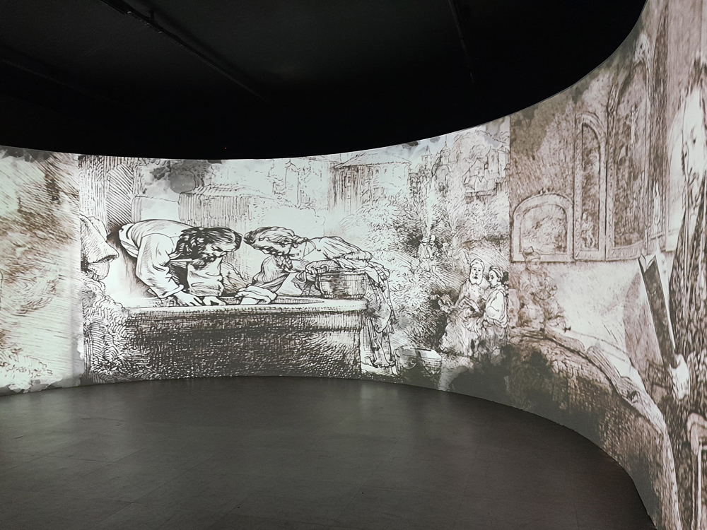 Sala imersiva da exposição de, onde gravuras do artista são projetadas em grande escala nas paredes curvas, criando uma experiência audiovisual envolvente.