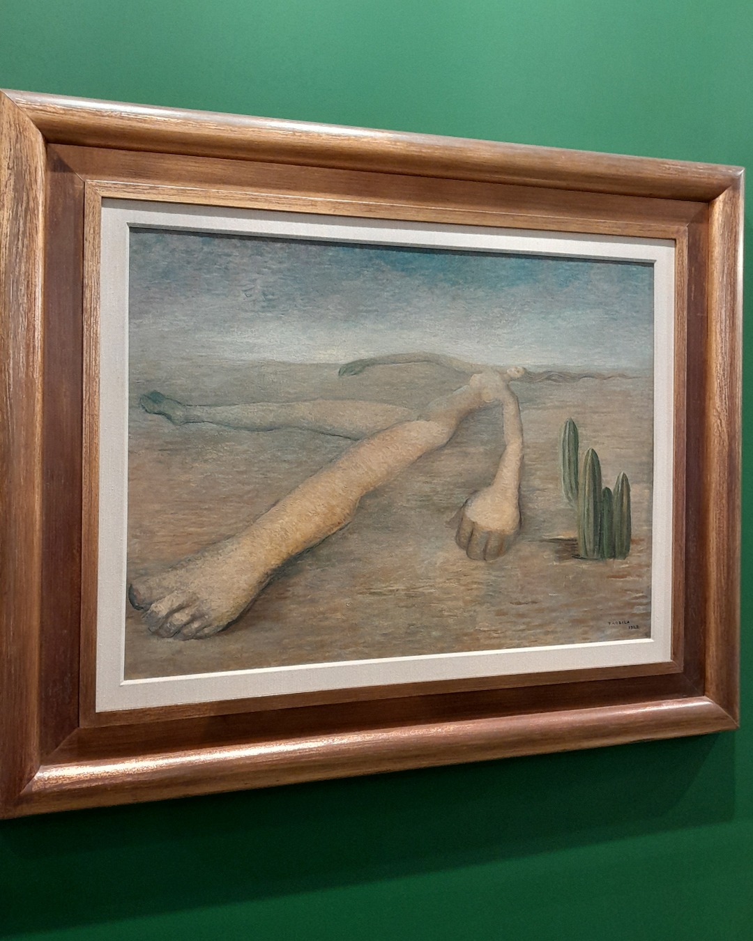 Pintura de Tarsila do Amaral retratando um cenário com uma pessoa deitada no chão e um cacto, em cores suaves.