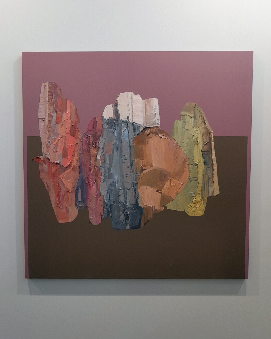 Obra abstrata de composta por formas de cores variadas em uma composição que soa como minerais. Fundo rosa com detalhe em marrom, destacando a textura grossa da tinta.