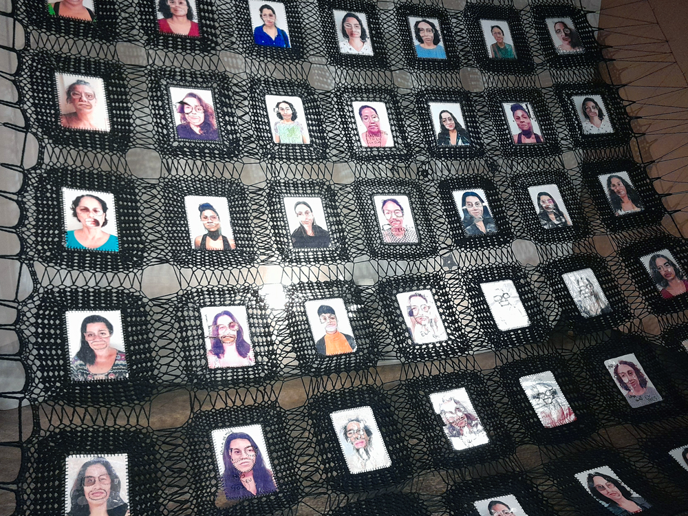 Grande instalação de Marlene Barros formada por uma rede preta de crochê suspensa no espaço, dividida em dezenas de nichos irregulares que abrigam pequenos retratos fotográficos. Muitos rostos foram interferidos com desenhos, palavras, linhas e bordados sobre olhos, boca, testa e pescoço. A trama preta deixa o ambiente visível através dos espaços vazados e transforma o conjunto de retratos em uma extensa composição coletiva.